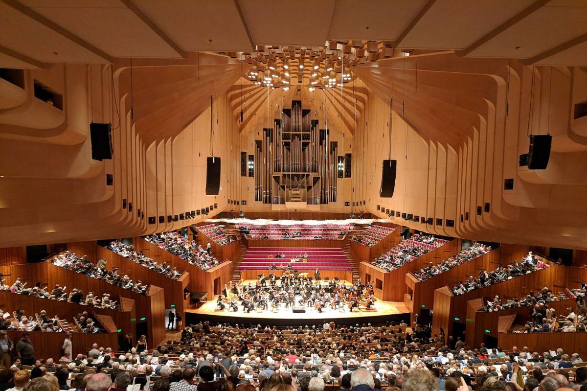 Interior of the Sydney Opera House Concert Hall, showing the ribbed plywood ceiling above the stage and the Grand Organ