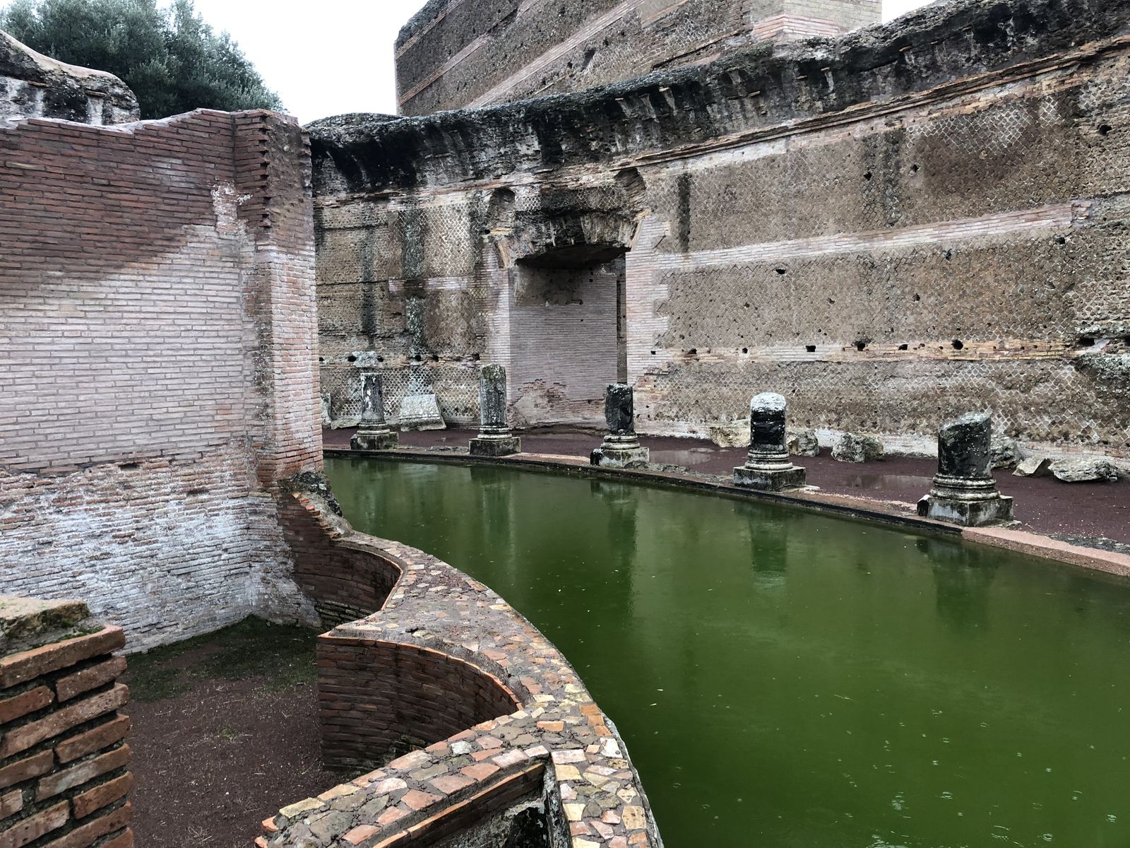The high enclosure wall of the Teatro Marittimo seen from the island villa across the moat